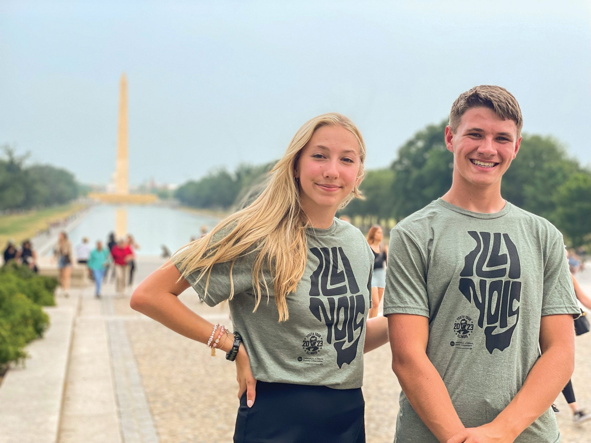 A teenage girl and boy standing before the Washington monument